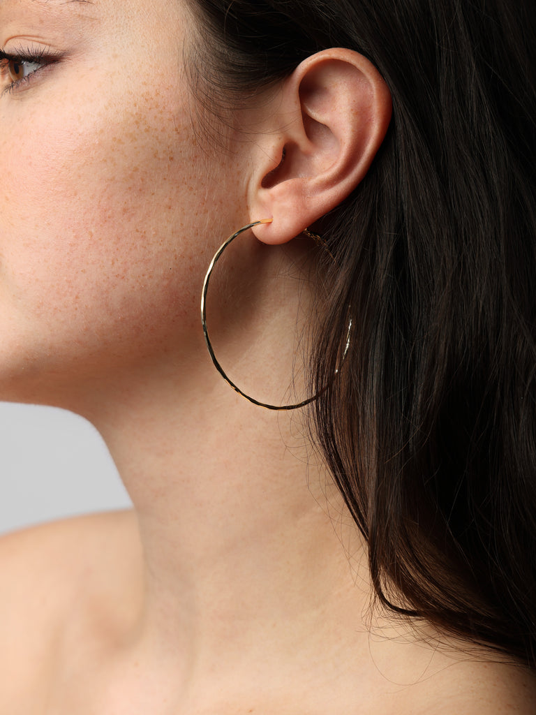 image of woman wearing thin gold hoop earrings