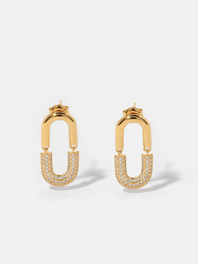 gold stud earrings in the shape of U link shape. Half of motif is covered in clear-colored crystals 