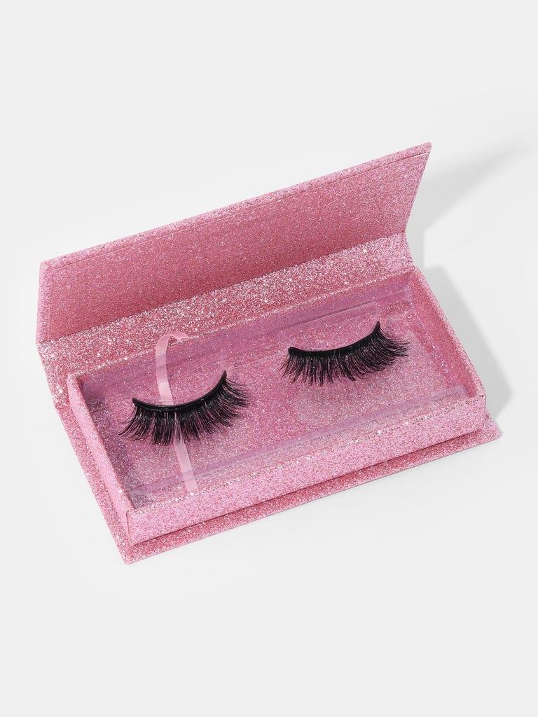 a pair of Doll Volume Magnetic Eyelashes inside an open pink glitter box