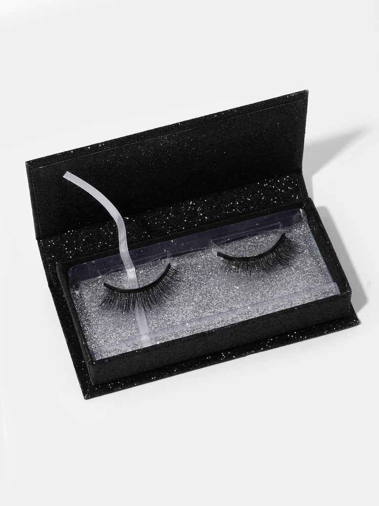 a pair of Angel Volume Magnetic Eyelashes inside an open black box with glitter