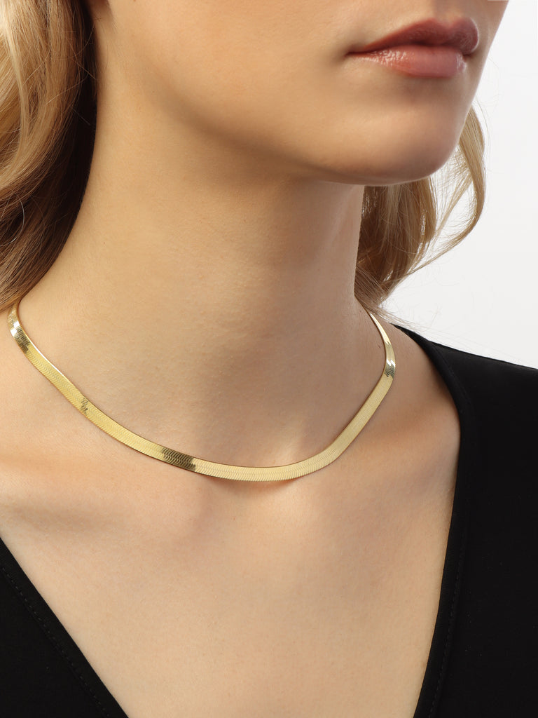 woman wearing thick gold herringbone chain necklace