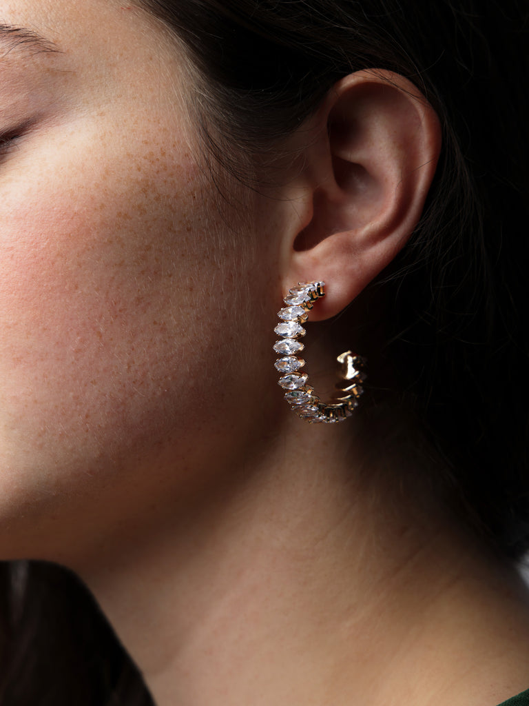 Woman wearing a gold marquise cut crystal hoop on her ear