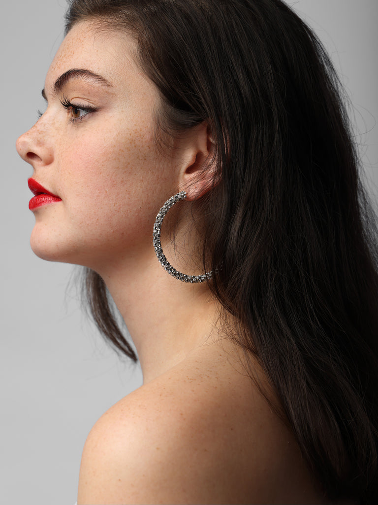 image of woman wearing silver hoops covered in small crystals