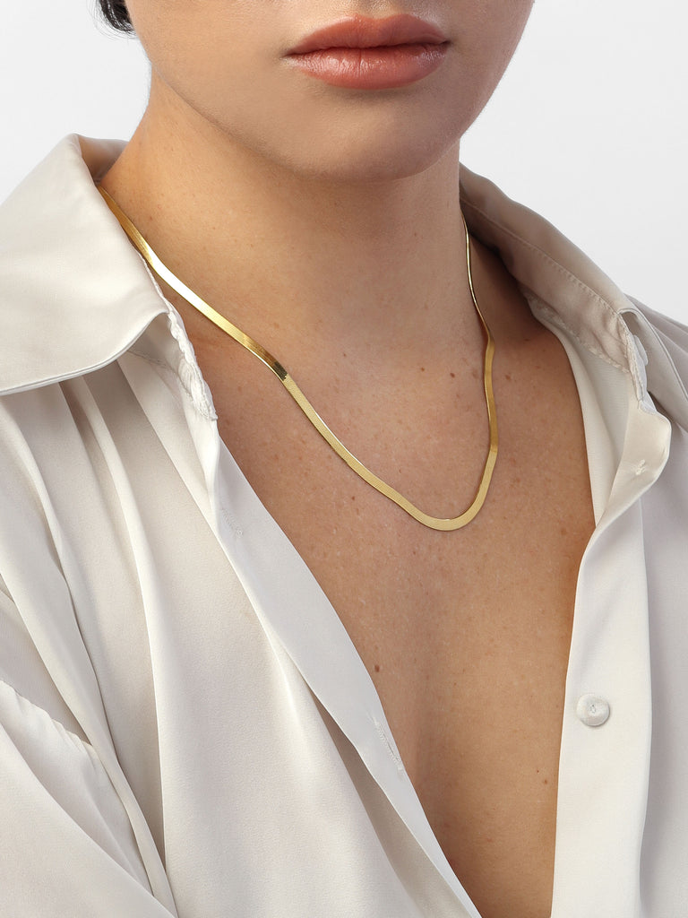 woman wearing gold necklace with thick herringbone chain
