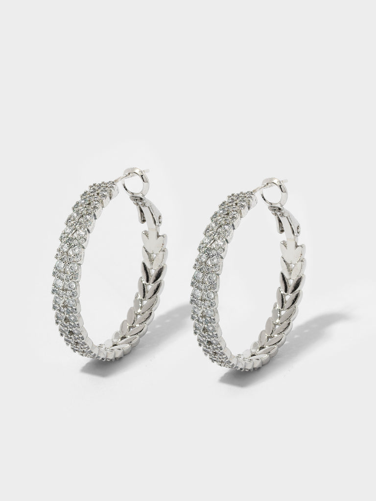 Product image of silver hoops with leaf shaped motif covered in small crystals 