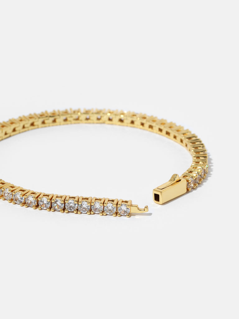 opened gold bracelet with clear-colored crystal gems all around