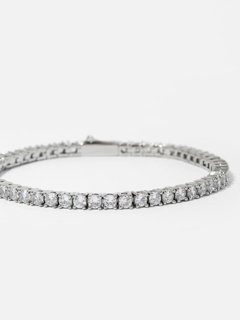 silver bracelet with clear-colored crystal gems all around