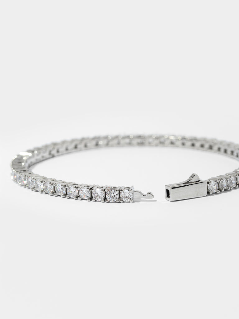 opened silver bracelet with clear-colored crystal gems all around