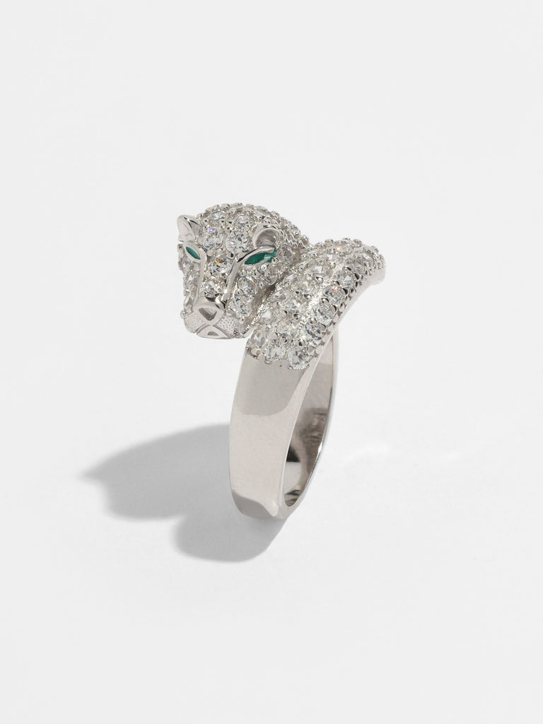 silver panther face shaped ring with face covered in clear-colored crystals and green gems for eyes. 