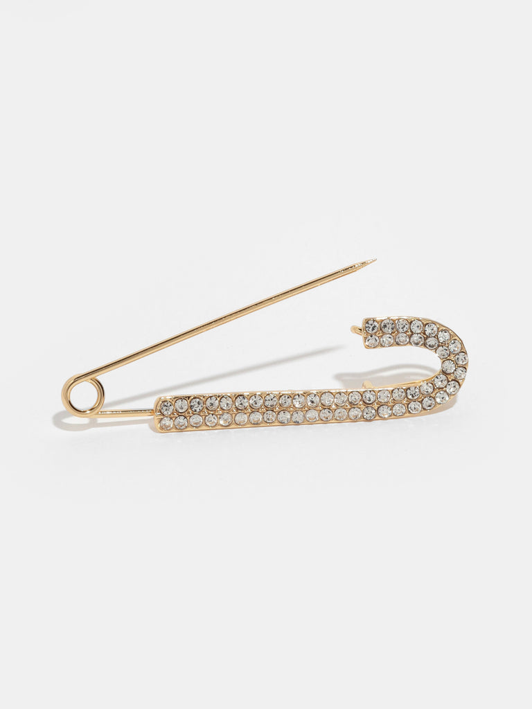 opened large gold safety pin with one side lined with small clear-colored crystal gems