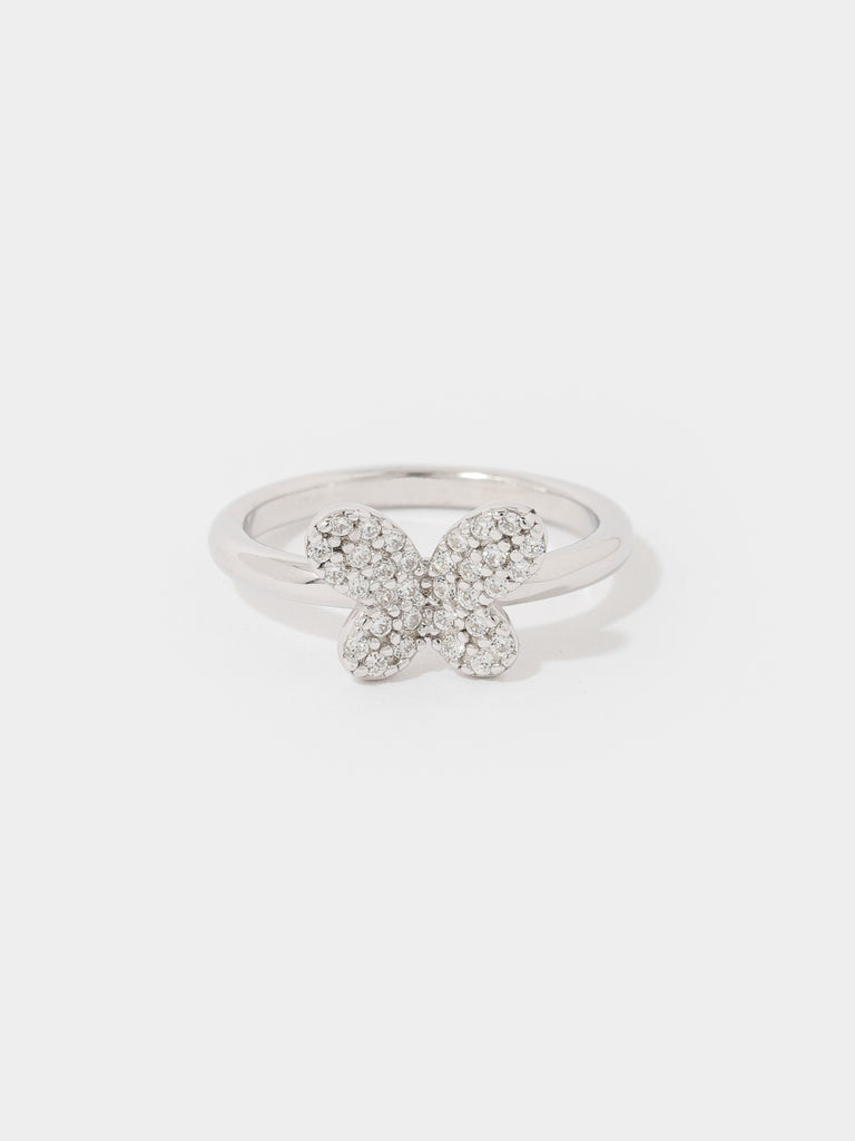 silver ring with butterfly motif in the center covered by small clear-colored crystal gems