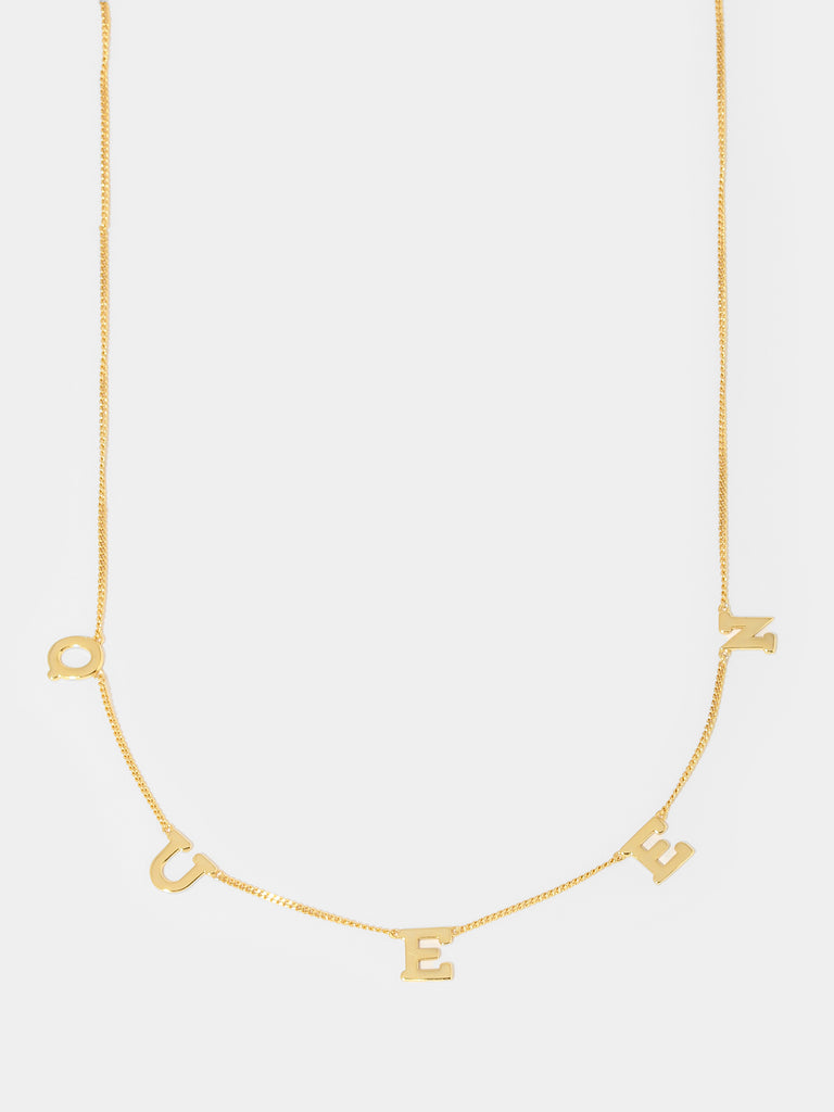 gold necklace with pendants with letters Q, U, E, E, N