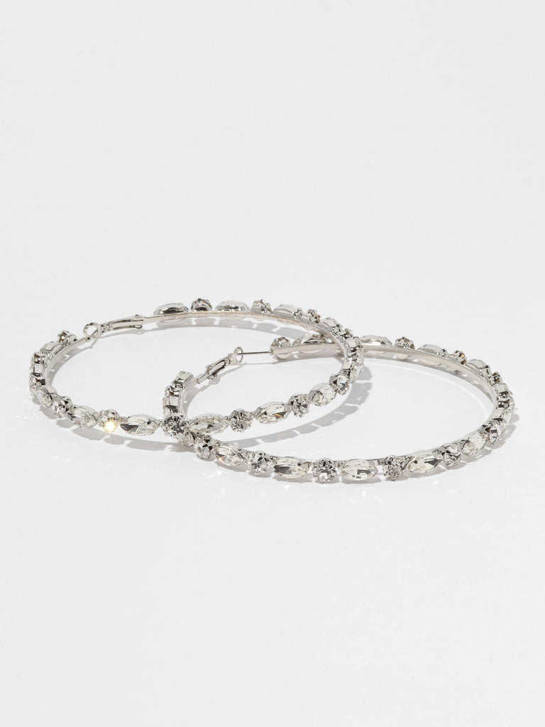 silver hoop earrings lined with round and marquise shaped clear-colored crystal gems