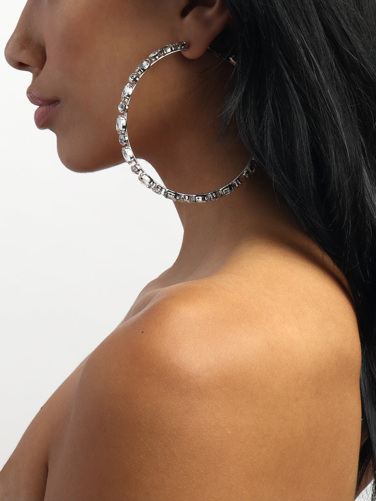 woman wearing silver hoop earrings lined with round and marquise shaped clear-colored crystal gems