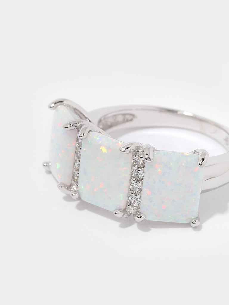 silver ring with 3 square shaped opal gems and two columns of clear-colored crystals in between them