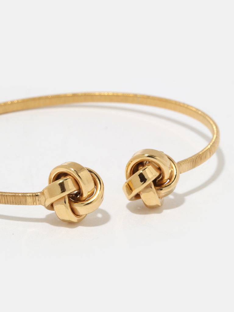 gold bangle bracelet with knotted ball motif in the ends