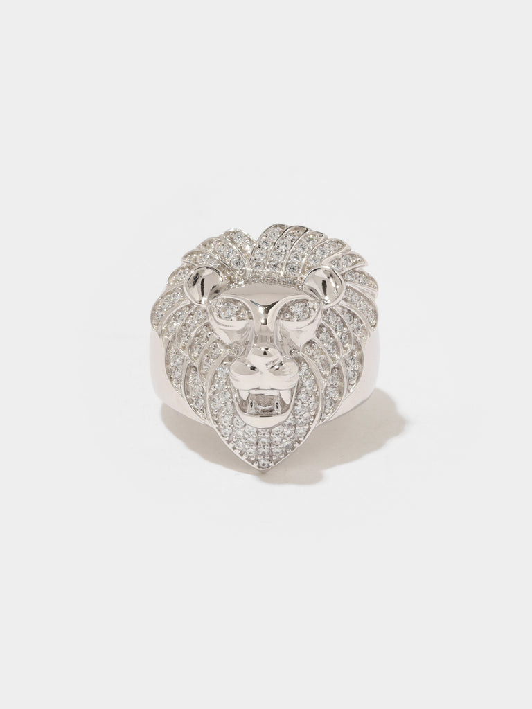 silver ring lion head shaped head in center and small clear-colored crystals adorning it's mane and eyes