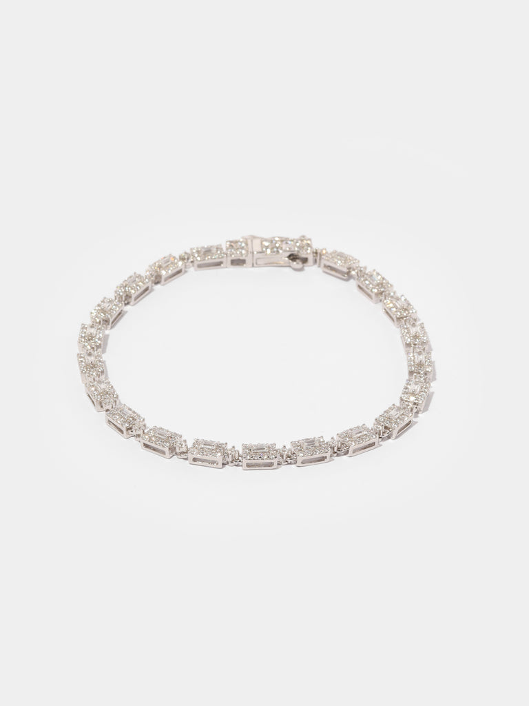 silver bracelet with rectangular link motif. In the center is a rectangle shaped, clear-colored gem outlined by small round clear-colored crystals