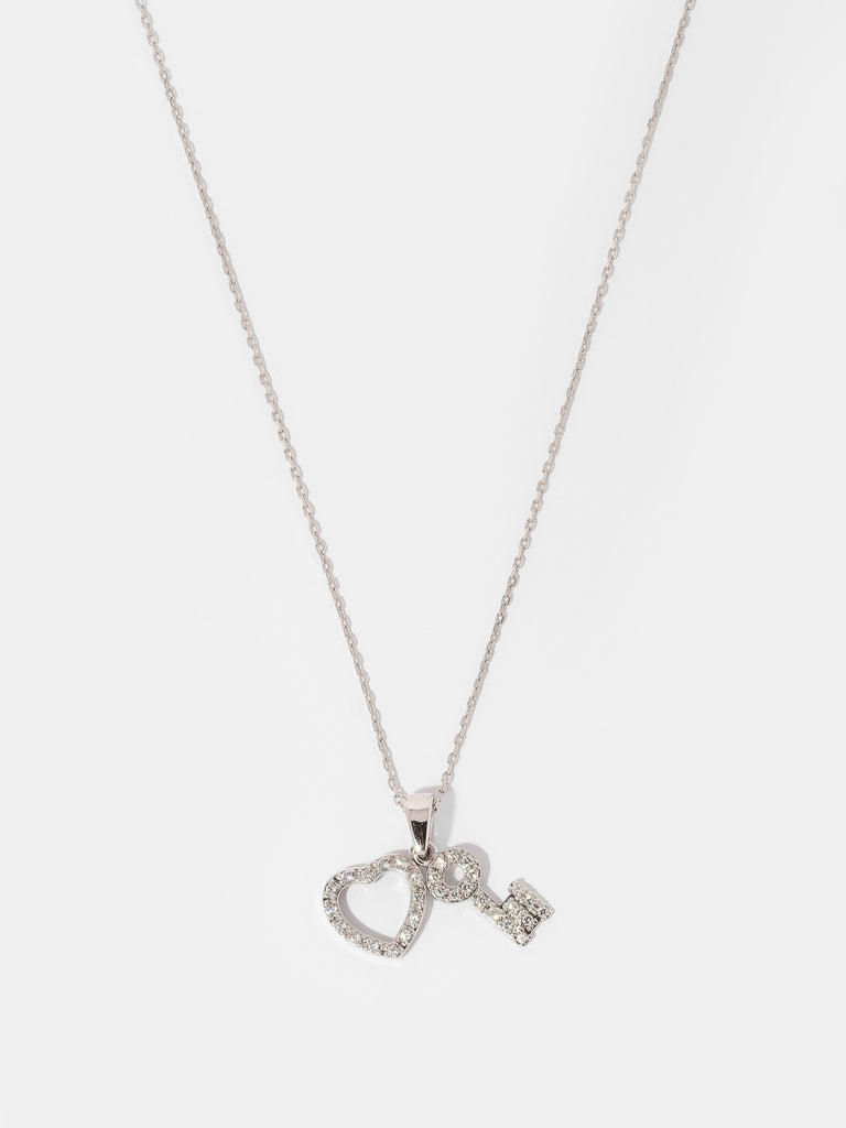 silver necklace with two pendants covered in clear-colored crystals in the shape of a heart and key